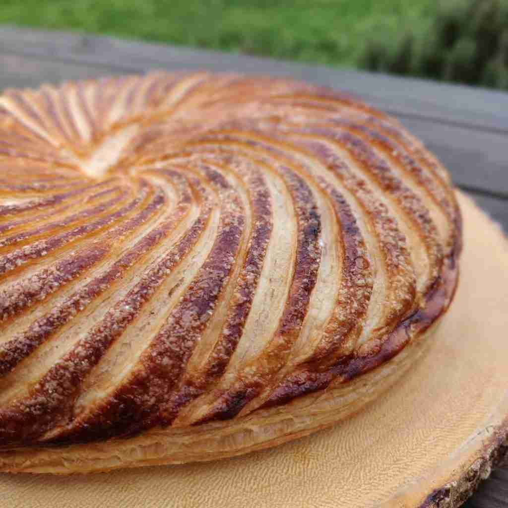 picture of a galette des rois on a wooden board, you can find the recipe on the blog of cookery school gourmandises academie, cambridge