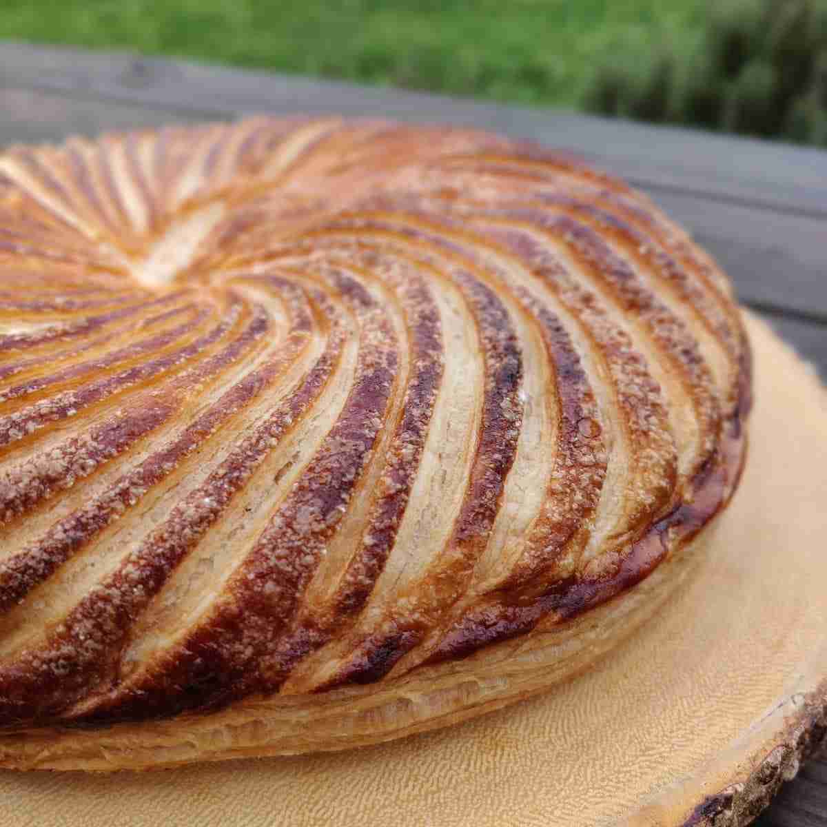 picture of a galette des rois on a wooden board, you can find the recipe on the blog of cookery school gourmandises academie, cambridge