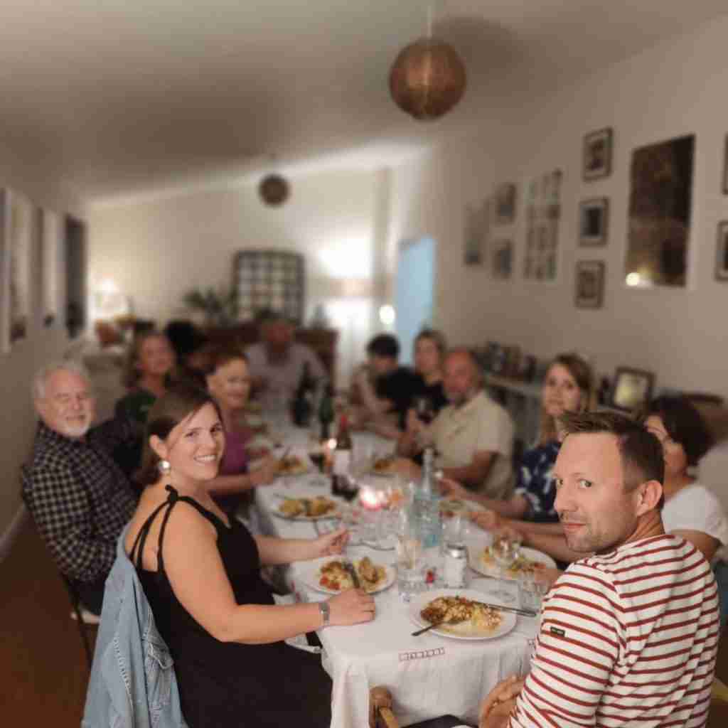 Picture of people sitting around the dining table, during the supper club "le bistrot clandestin" at the cookery school Gourmandises Academie, Cottenham