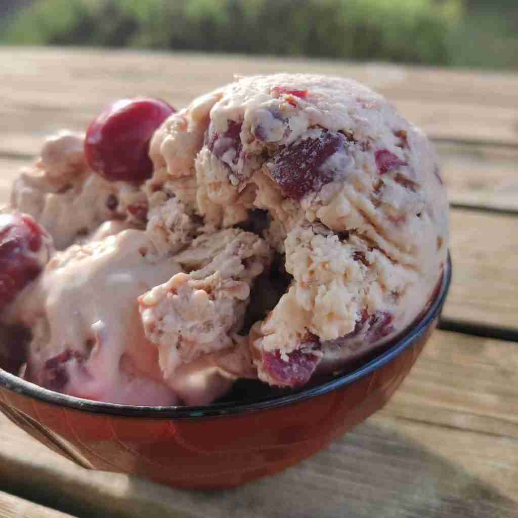 image with a bowl of ice cream with cherries inside, the recipe can be found on the blog of Gourmandises Academie, Cottenham, UK