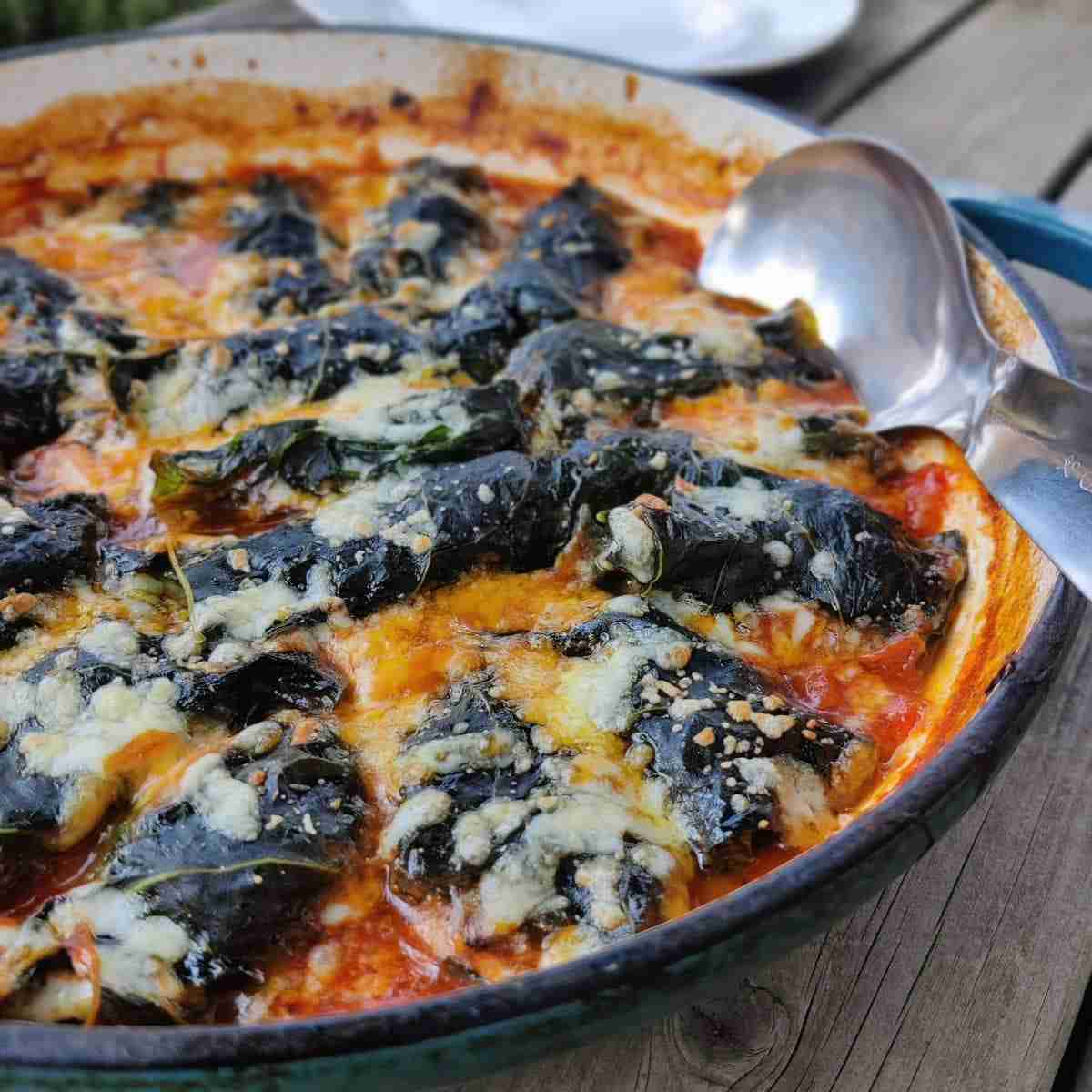 Image with a pan filled with cabbage rolls in a tomato sauce, the recipe can be found at cookery school Gourmandises Academie