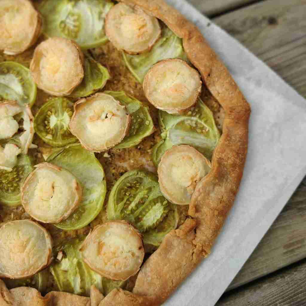 image of a tart with sliced green tomatoes and goat cheese on top, you can find the recipe on the blog of Gourmandises Academie, Cambridge