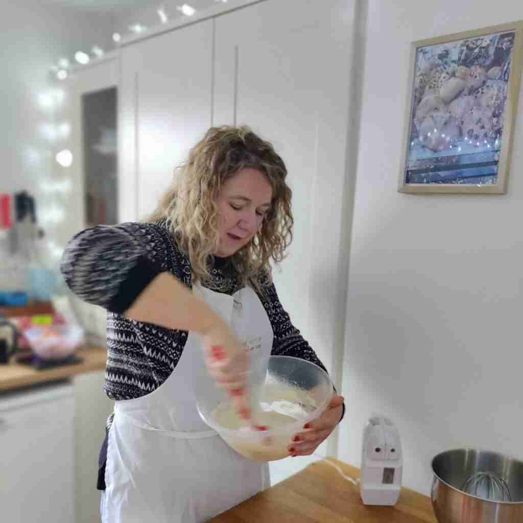 image of a lady mixing cream in a bowl during a Christmas baking class at cookery school Gourmandise Academie, cambridge