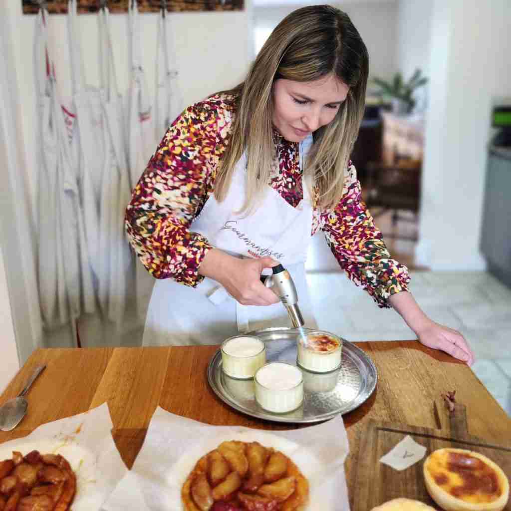 image of a girl torching the creme brulee at cookery school Gourmandises Academie
