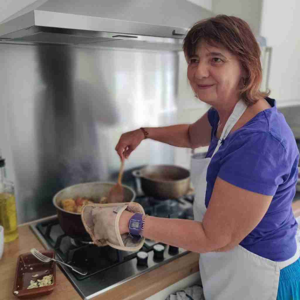 image of a lady cooking and stirring in front of a stove