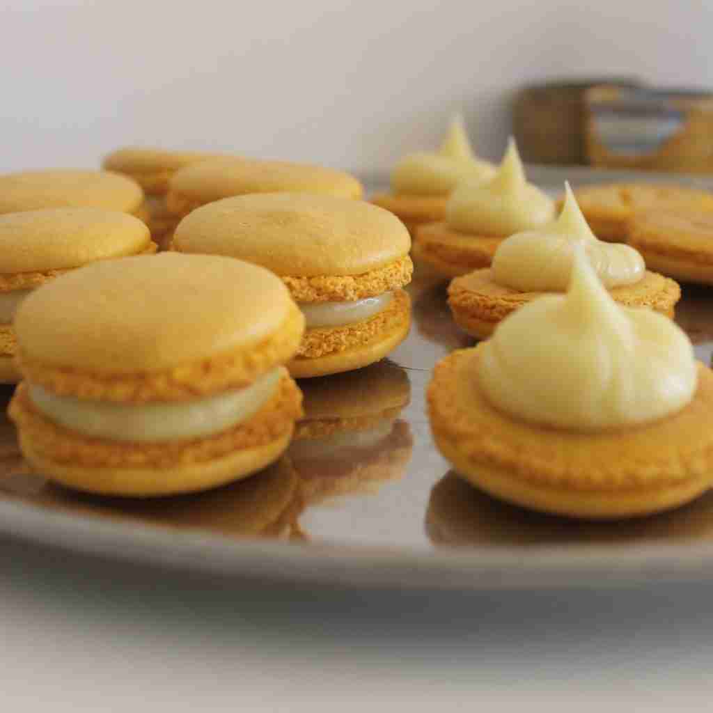 image of yellow macarons, some are opened with the lemon filling on top
