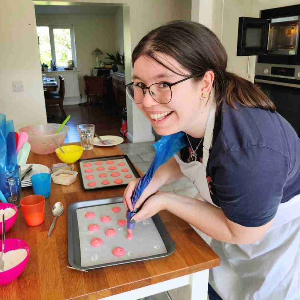 image of a girl piping pink macarons