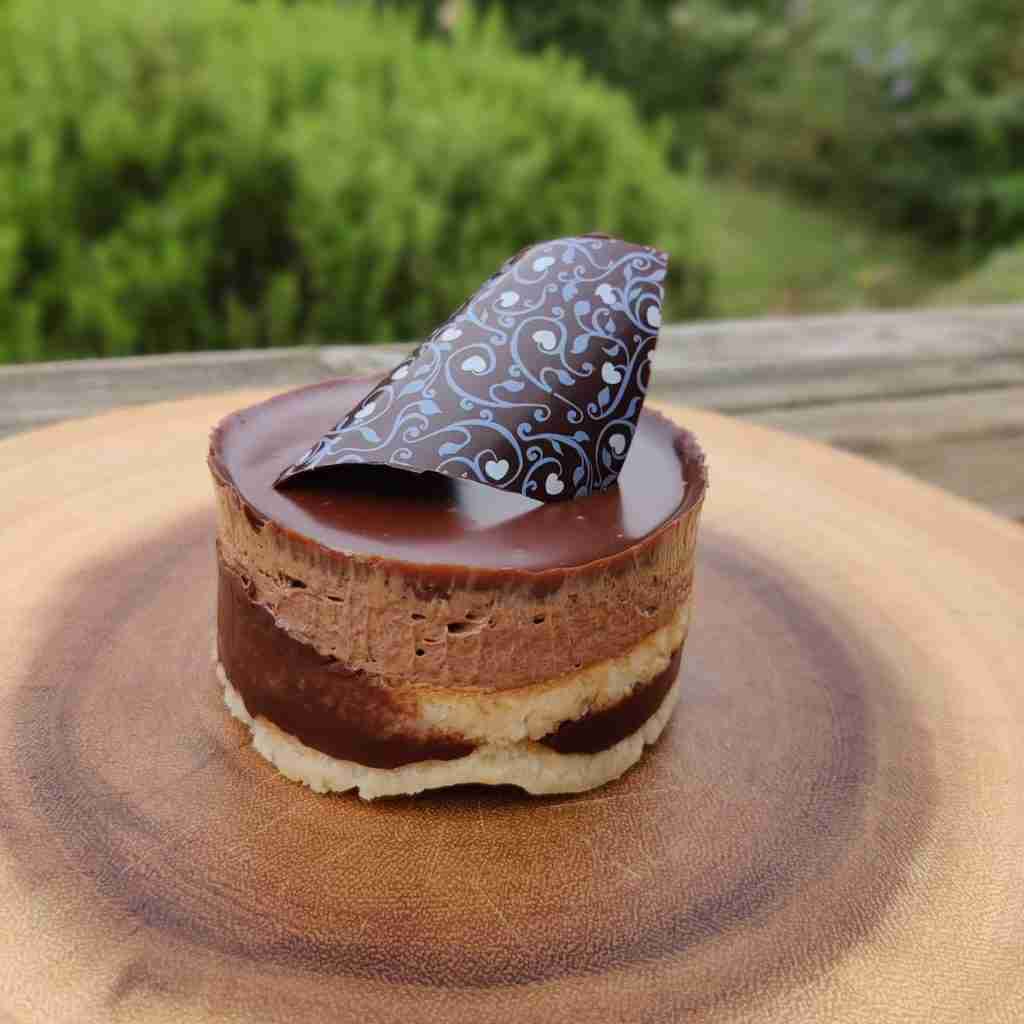 image of a small chocolate layered cake with a chocolate decoration on top