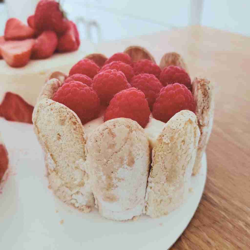 image of a charlotte cake topped with fresh raspberries. You can learn how to make this French patisserie at cookery school Gourmandises Academie, Cambridge