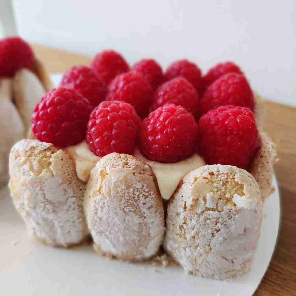 image of a charlotte cake topped with fresh raspberries, you can learn how to make this French cake at cookery school Gourmandises Academie, Cambridge