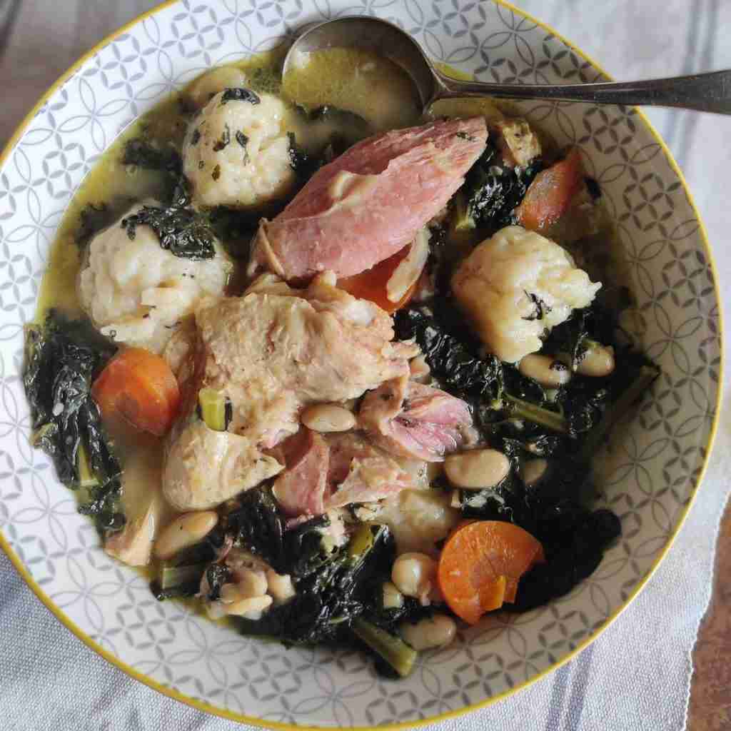 image of a bowl of stew with dumplings, ham, chicken and vegetables, you can find this recipe at cookery school gourmandises academie, Cambridge