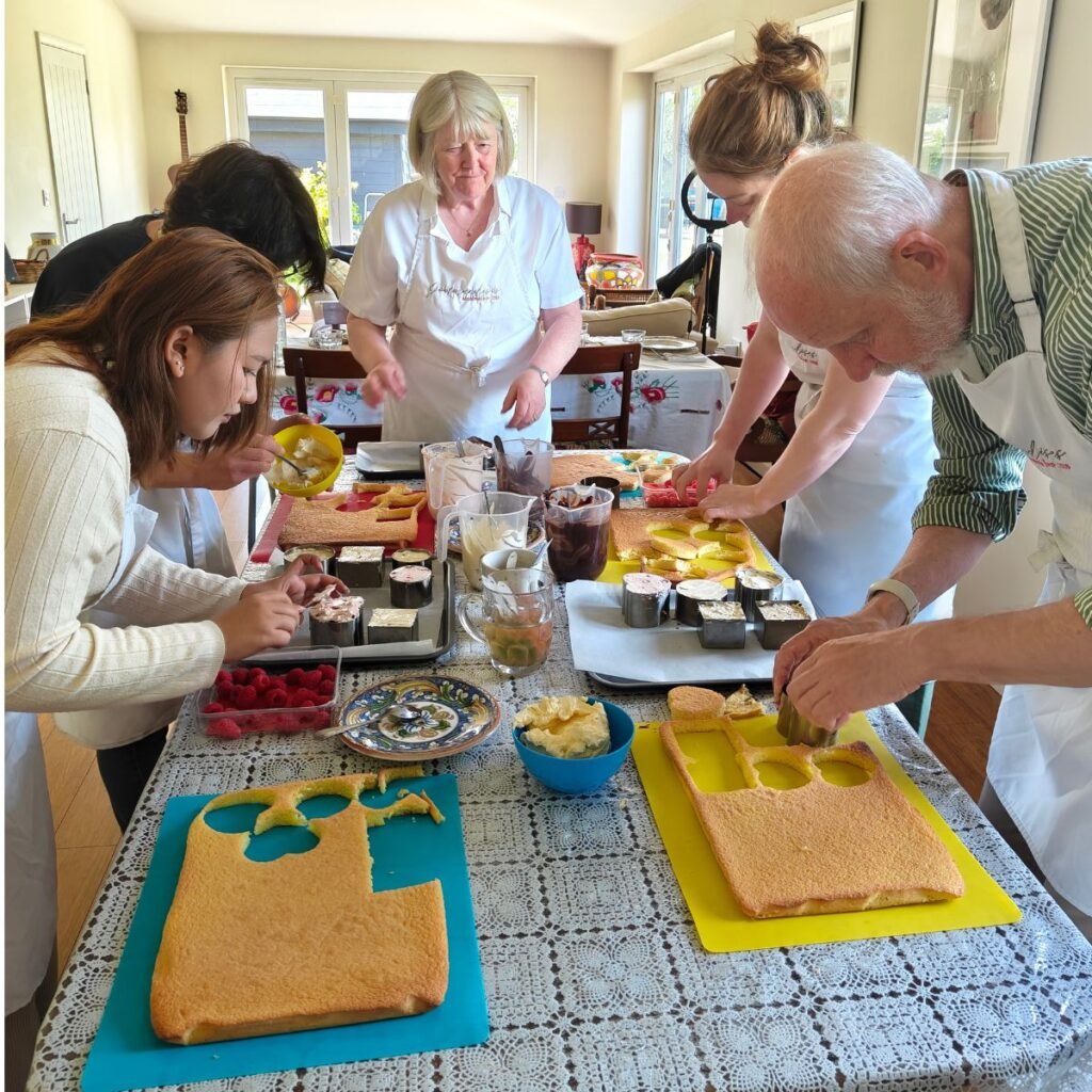 image of five people, cutting their genoise sponge into shape