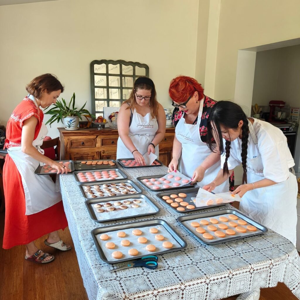 image of fours ladies working with a selection of multicoloured macarons laid out on a table