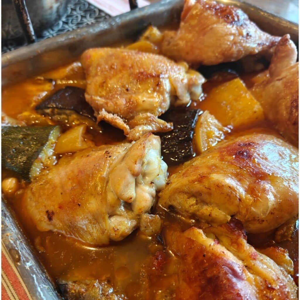 picture of cooked chicken thighs in a spicy tomato sauce with courgettes